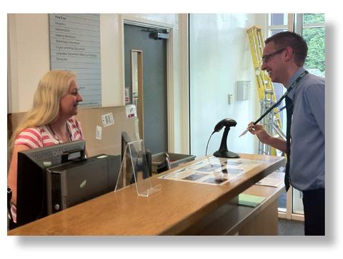 Visitor checking in at school reception with scanner | Visitor Management Software Solutions | SG World